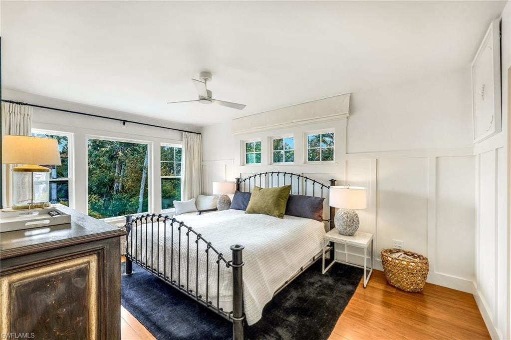 Bedroom featuring a decorative wall, ceiling fan, and wood finished floors