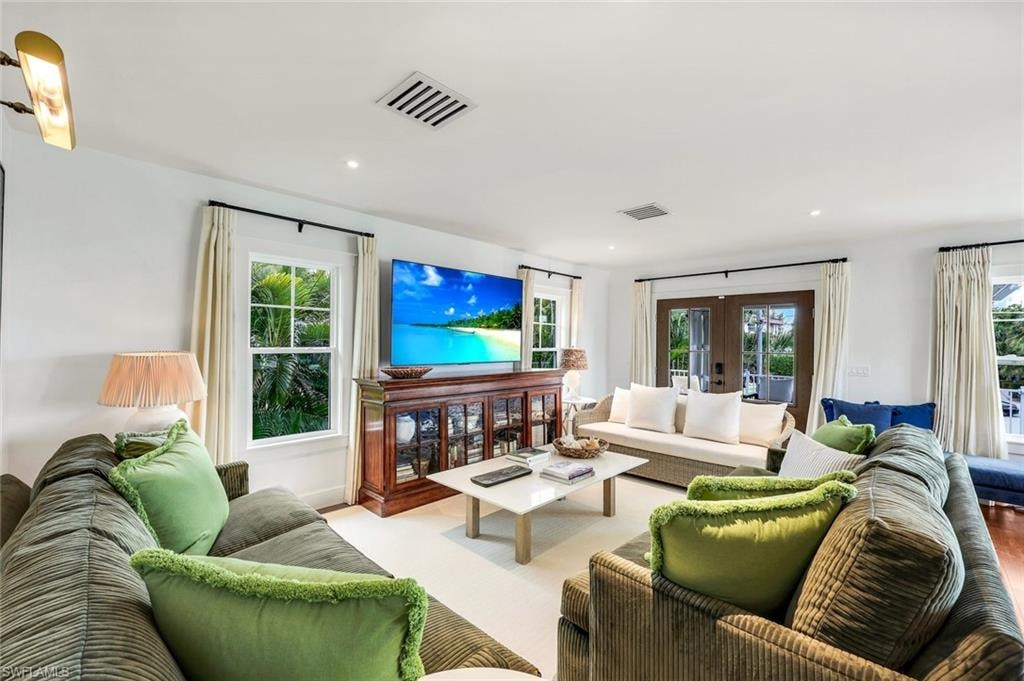 Living room with recessed lighting, visible vents, and french doors