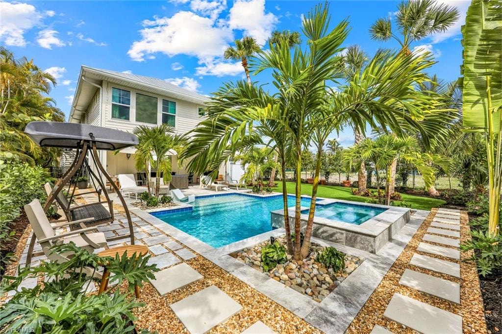 View of swimming pool with a patio and a pool with connected hot tub