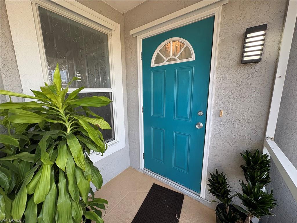 Doorway to property with stucco siding