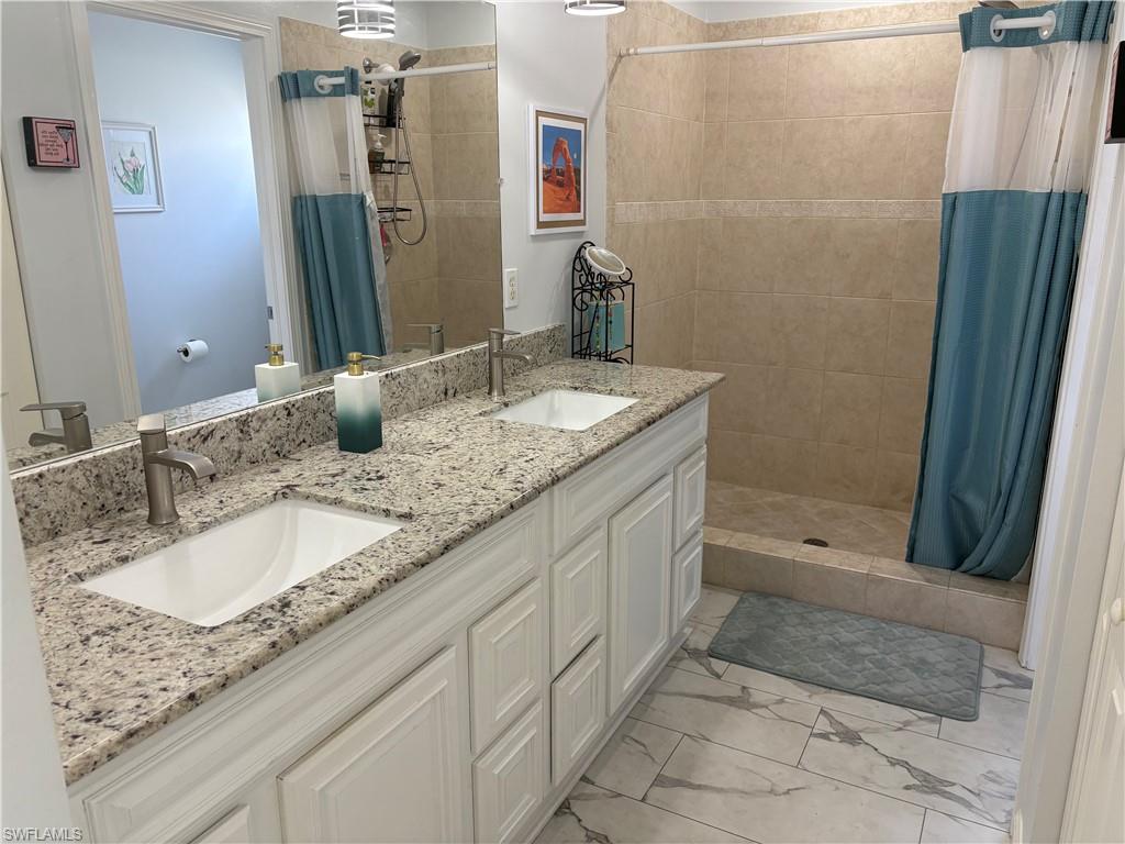 Bathroom featuring double vanity and a shower stall
