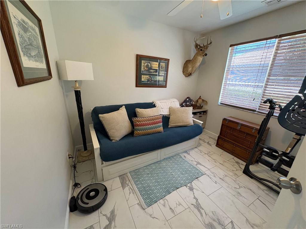light marble finish flooring and a ceiling fan