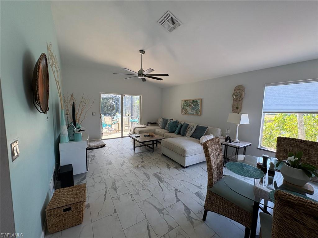 Living area featuring a ceiling fan and light marble finish flooring