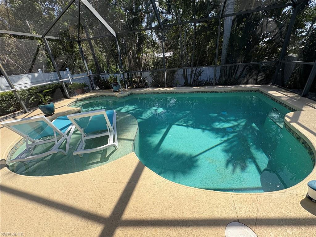 View of swimming pool  fenced backyard, patio surround, and a sunroom
