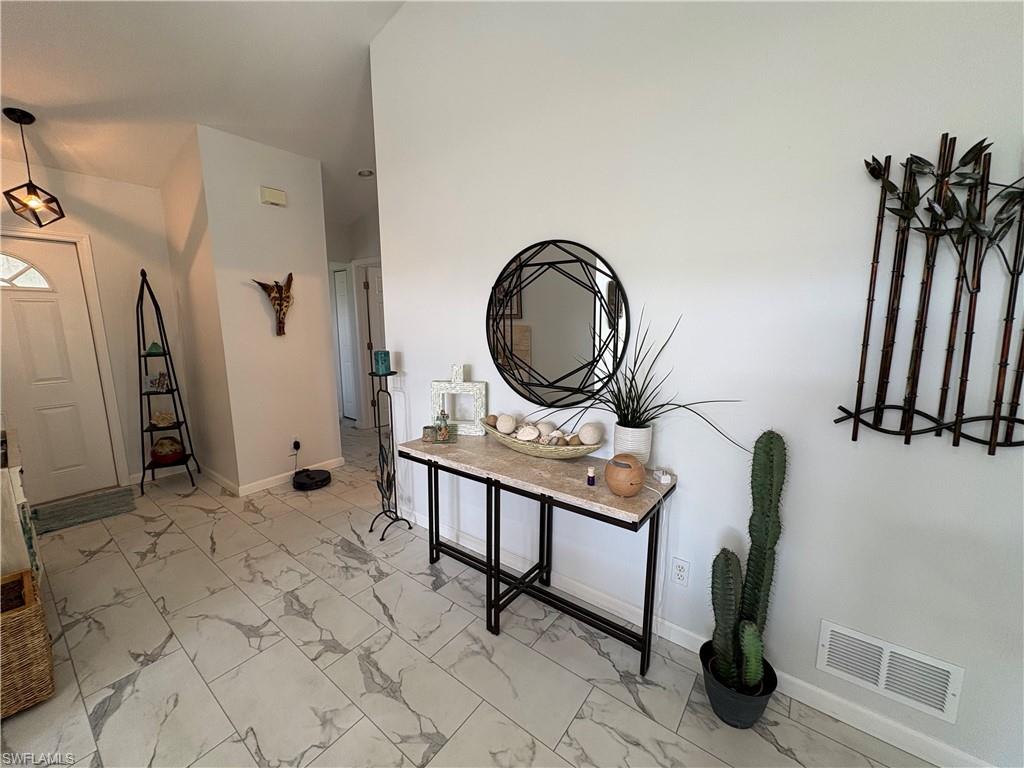 Foyer featuring light marble finish flooring and baseboards