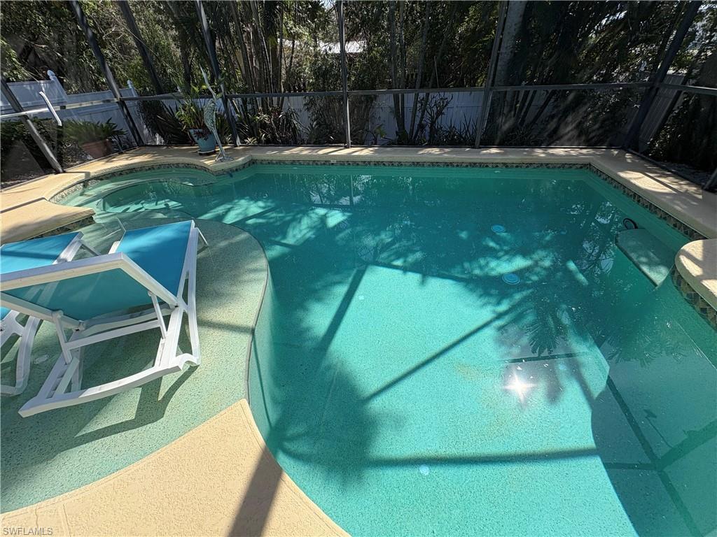 View of swimming pool featuring a fenced backyard and a lanai