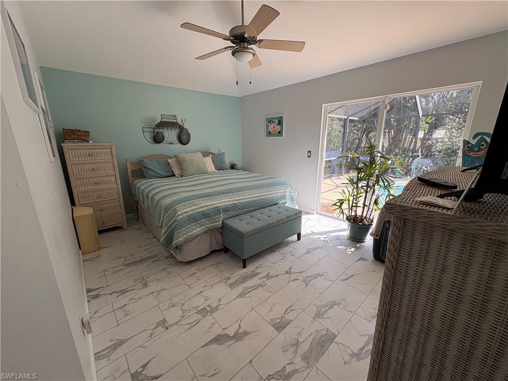 Bedroom with light marble finish flooring, access to exterior, and ceiling fan