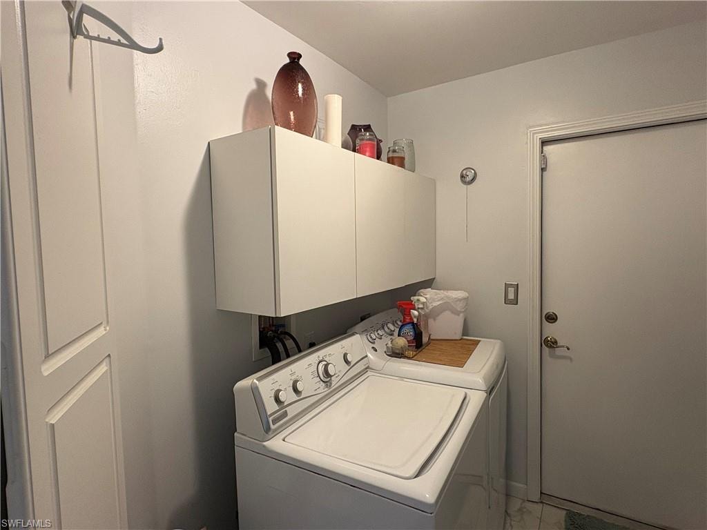 Laundry area featuring cabinet space and separate washer and dryer