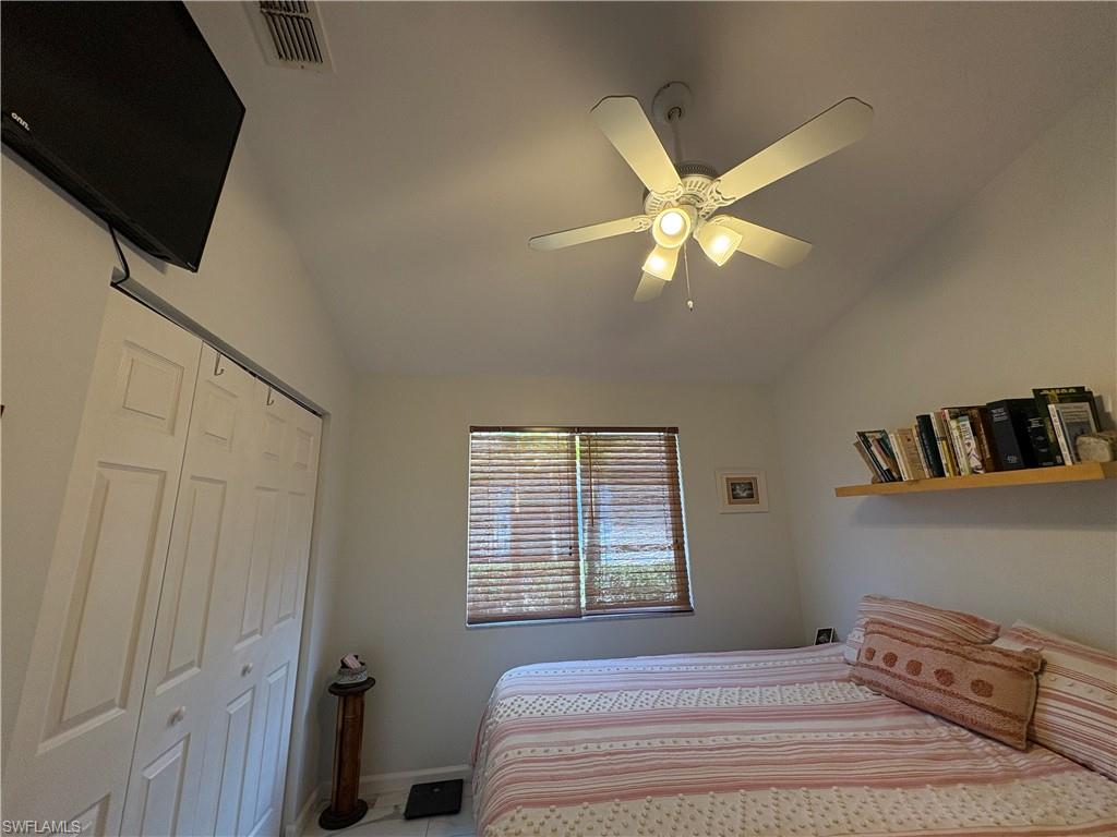 Bedroom featuring vaulted ceiling, a ceiling fan, and a closet
