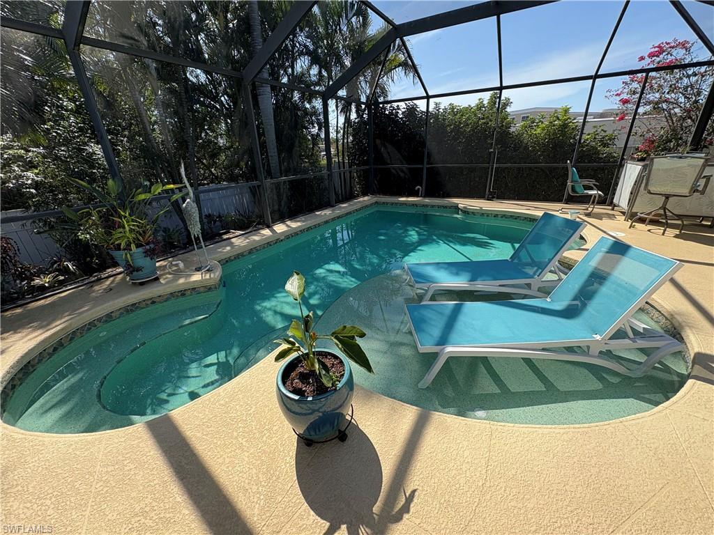 View of pool with a sunroom, and patio surround
