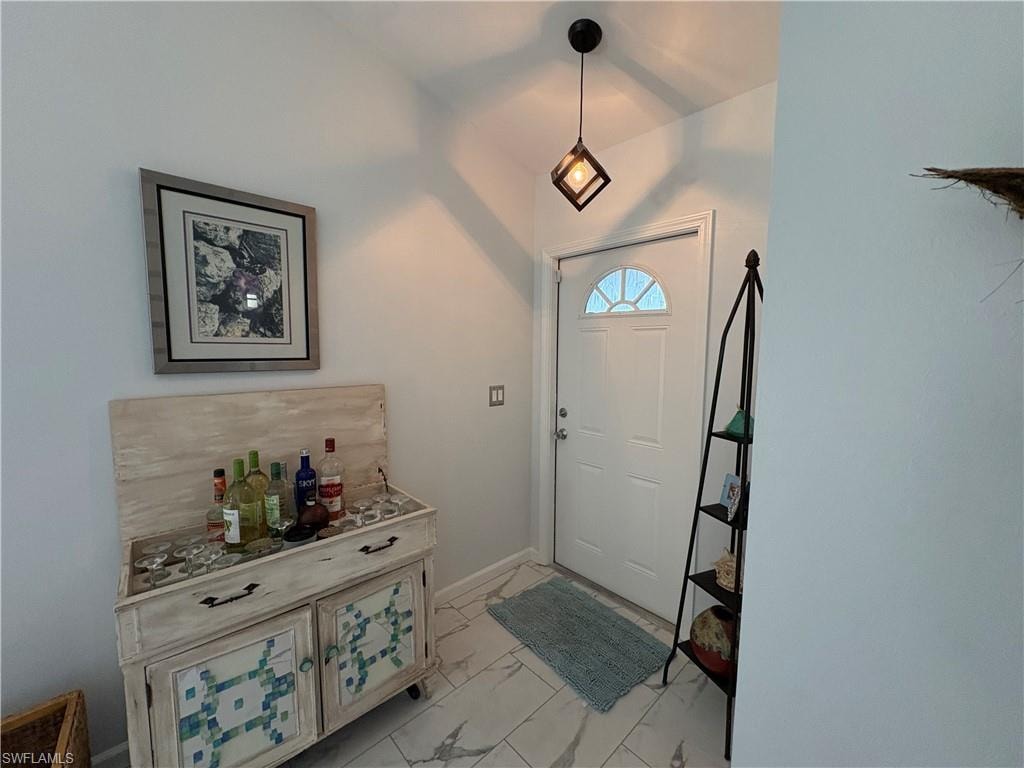 Entrance foyer featuring baseboards and light marble finish flooring