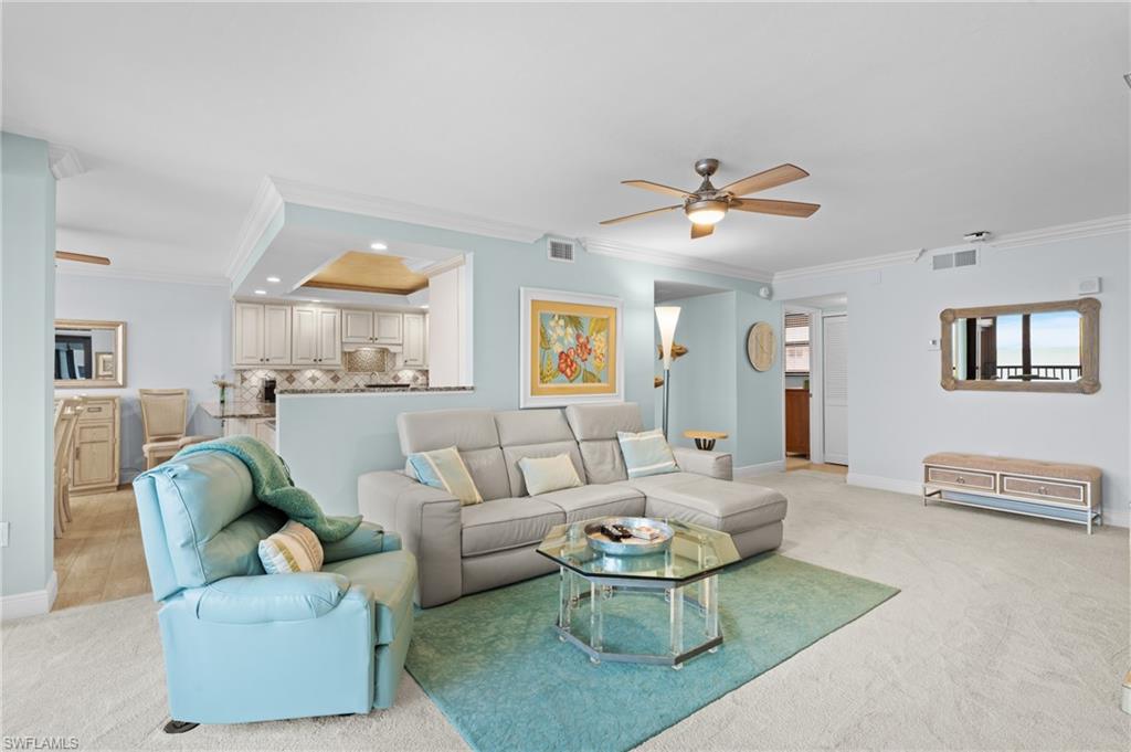 Living area featuring ceiling fan, ornamental molding, light carpet, and recessed lighting