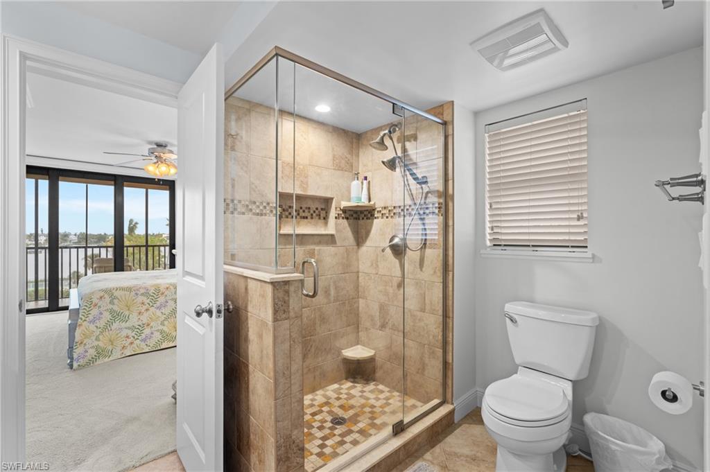 Ensuite bathroom featuring a shower stall and a ceiling fan