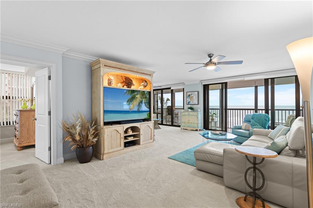 Living room featuring crown molding, light carpet, and ceiling fan