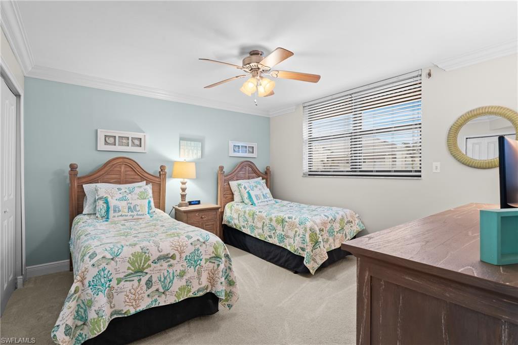 Bedroom featuring crown molding, light carpet, a closet, and a ceiling fan