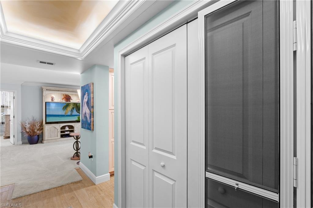 Hallway with crown molding and light wood-style flooring