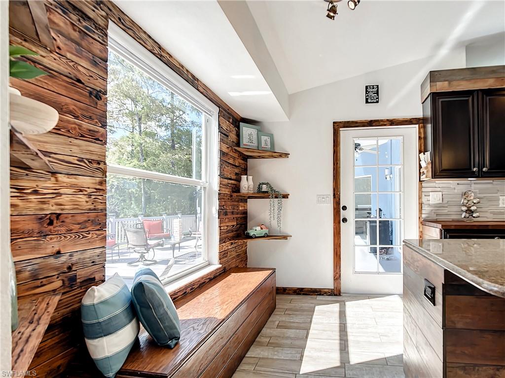Doorway featuring lofted ceiling and wood finish floors