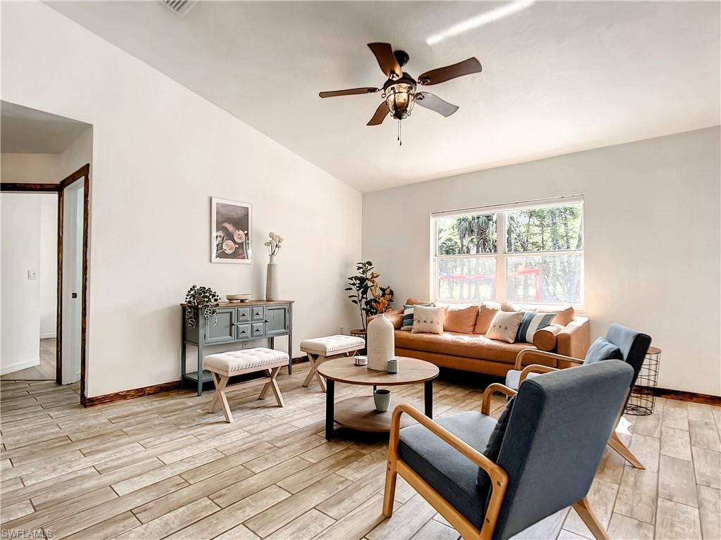 Living area with wood finish floors, vaulted ceiling, and ceiling fan