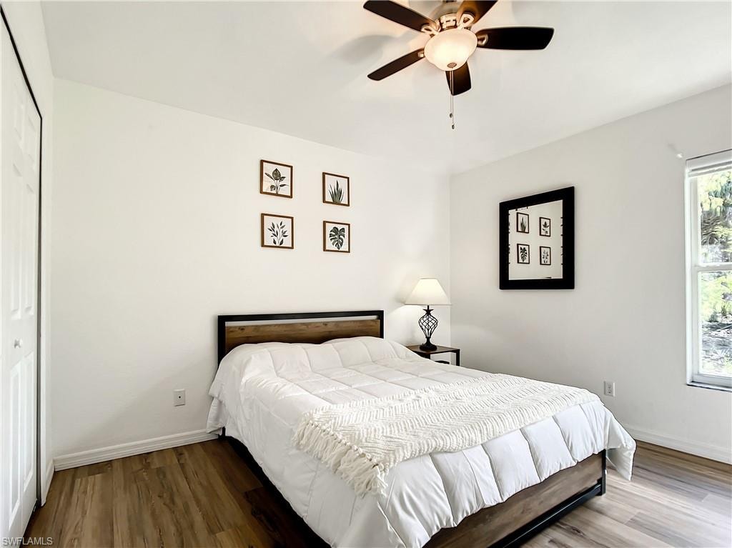 Bedroom with wood finished floors, a closet, and a ceiling fan