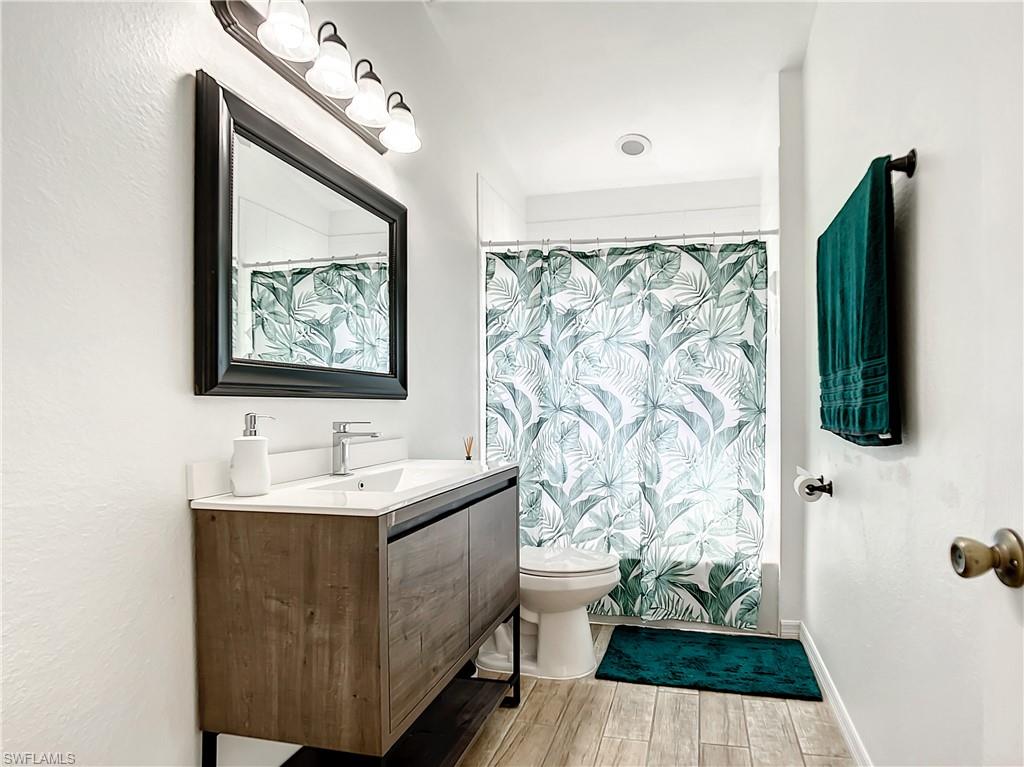 Full bath with vanity, wood tiled floors, and shower / tub combo with curtain