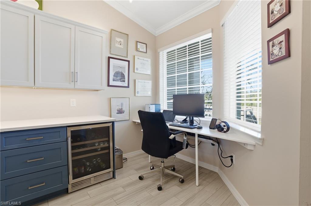 Office space featuring crown molding, beverage cooler, and wood finish floors