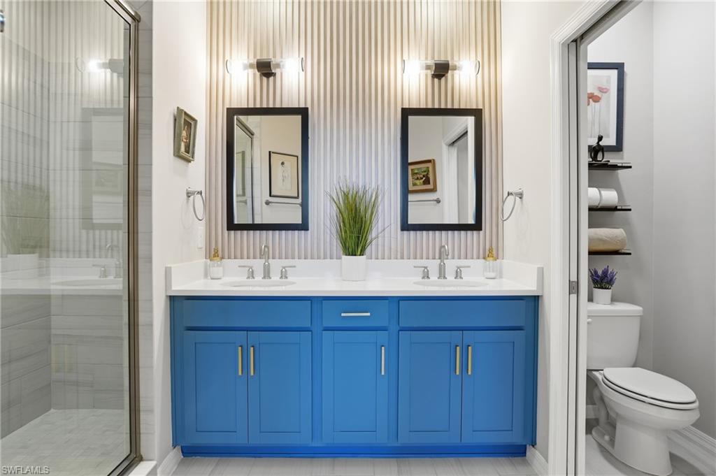 Bathroom featuring double vanity and a shower stall