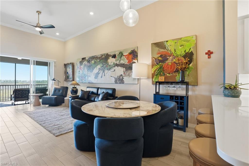 Dining area featuring ceiling fan, crown molding, wood tiled floors, recessed lighting, and a high ceiling
