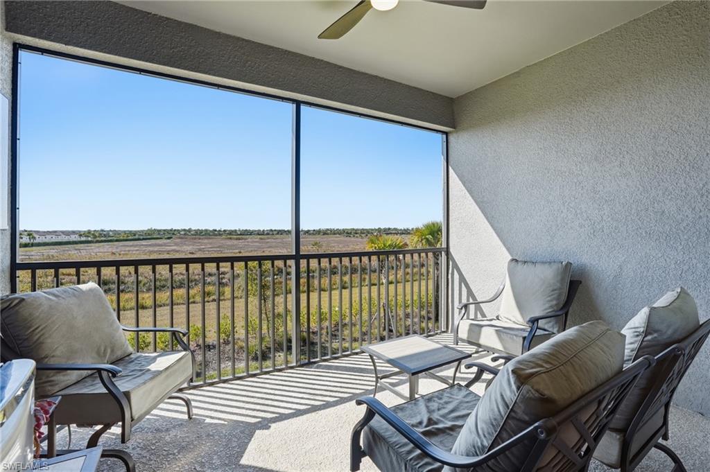 Sunroom with a ceiling fan and a balcony