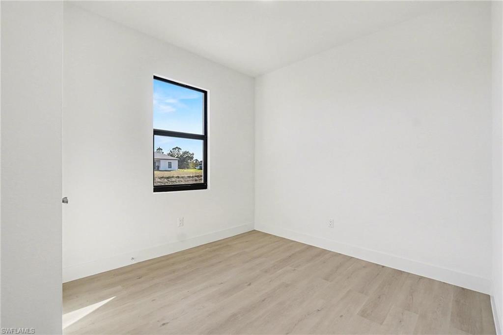 Spare room with light wood-style floors and baseboards
