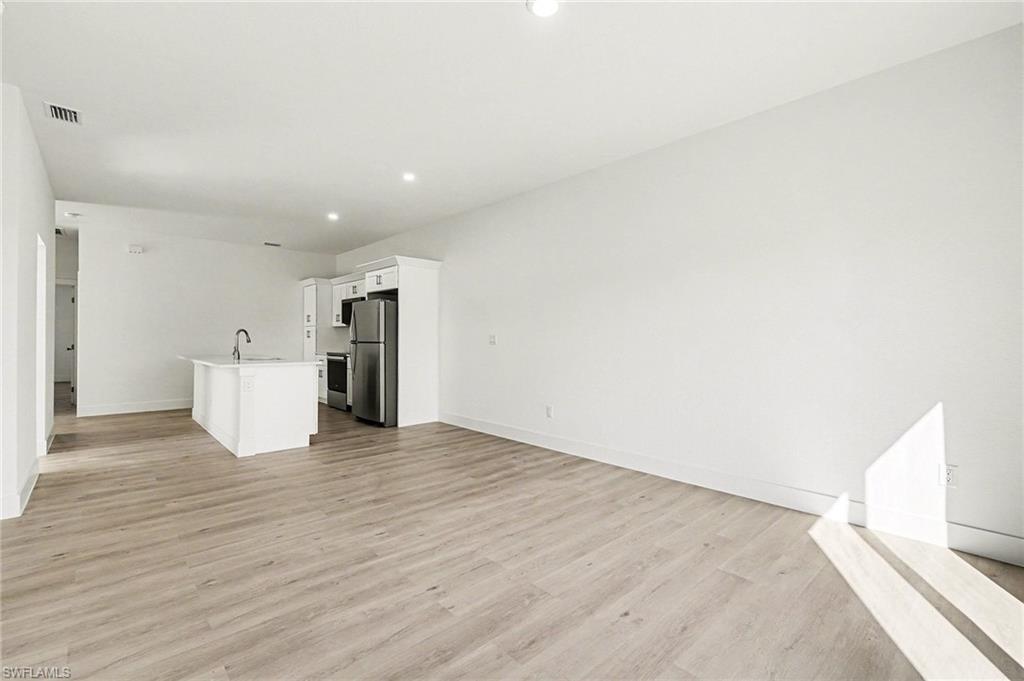 Unfurnished living room with light wood finished floors and recessed lighting