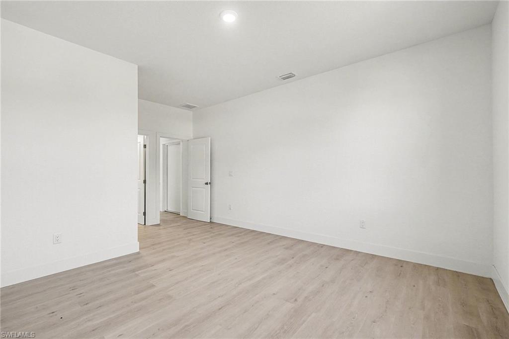 Unfurnished room with light wood finished floors and baseboards