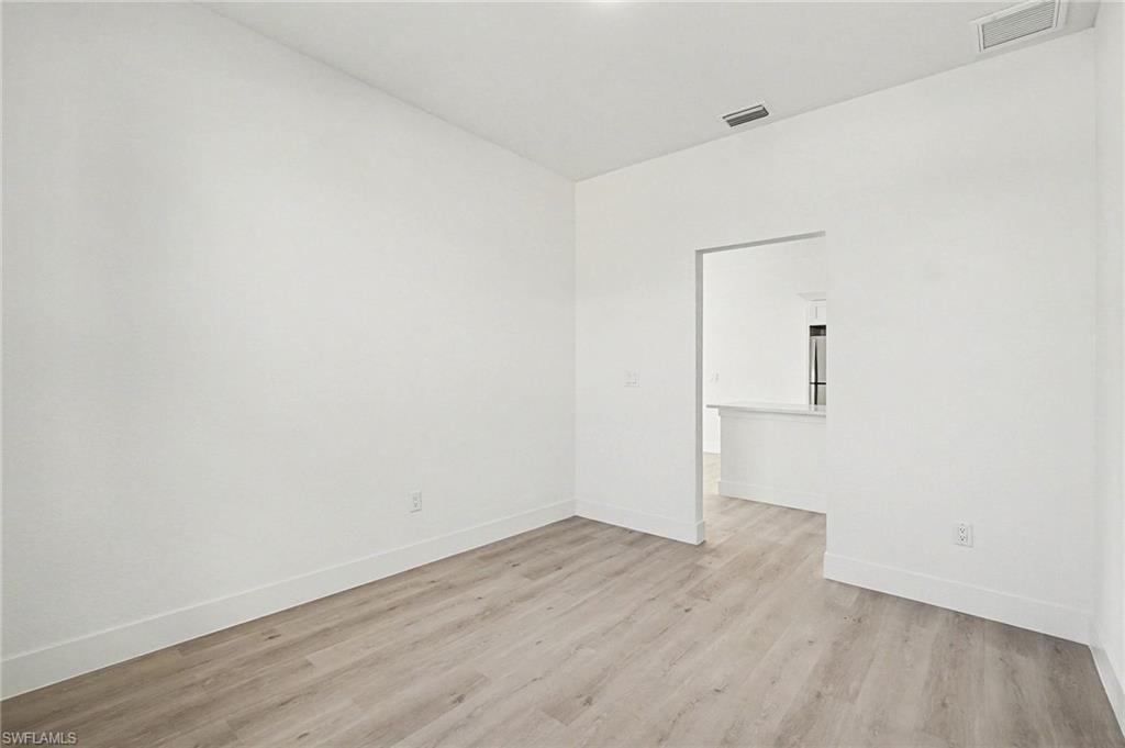 Unfurnished room featuring light wood-type flooring and baseboards