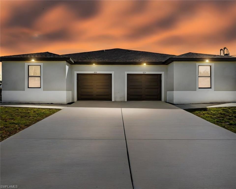 Prairie-style home with an attached garage, driveway, stucco siding, and a shingled roof