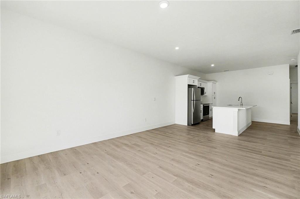 Unfurnished living room with light wood-type flooring and recessed lighting