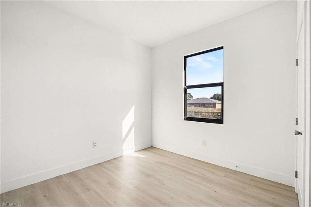 Unfurnished room featuring light wood-style floors and baseboards