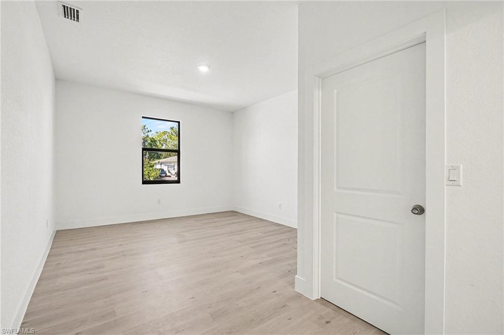Spare room with light wood-style floors and recessed lighting
