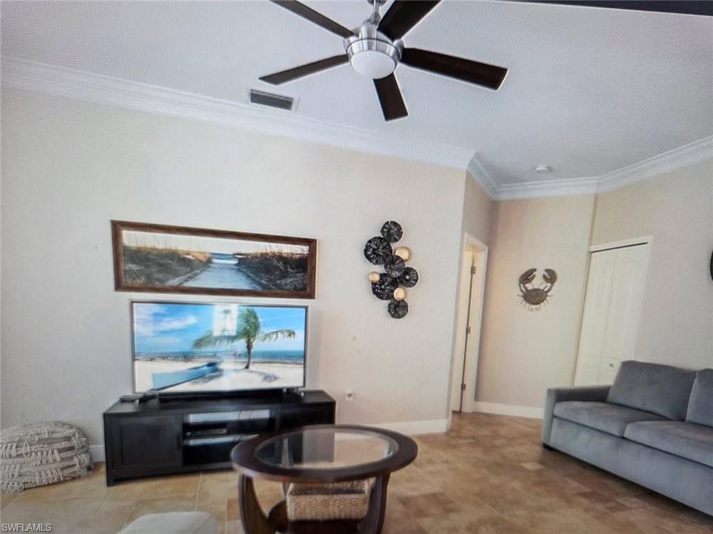 Living area featuring crown molding and ceiling fan