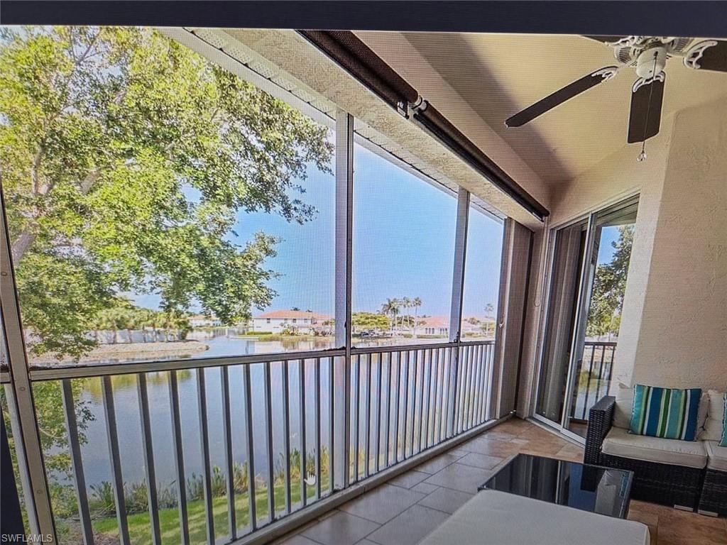 Sunroom with a textured wall and a water view
