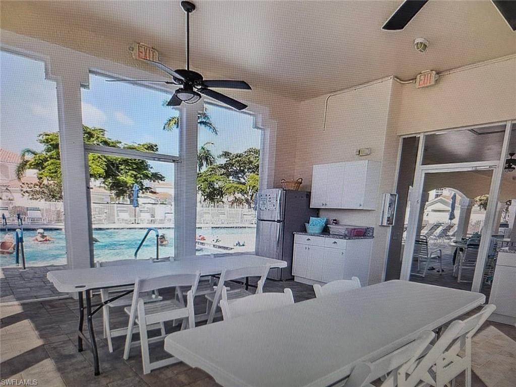 View of patio featuring outdoor dining area, a community pool, and ceiling fan