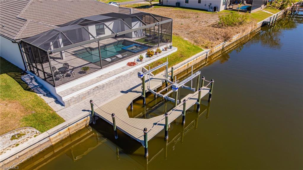 Dock area featuring an outdoor pool, boat lift, a lanai, a water view, and a sunroom