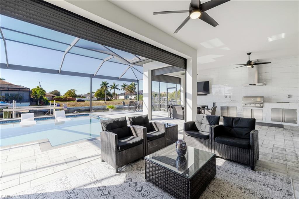 View of patio / terrace featuring a sunroom, an outdoor pool, ceiling fan, and a lanai