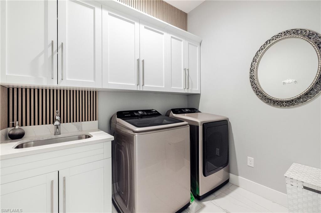 Laundry room with separate washer and dryer and cabinet space