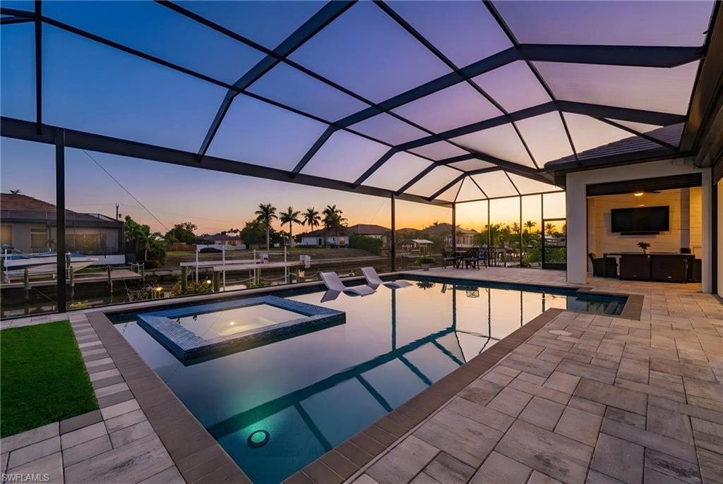 Integrated pool / hot tub featuring a sunroom, a patio area, and glass enclosure