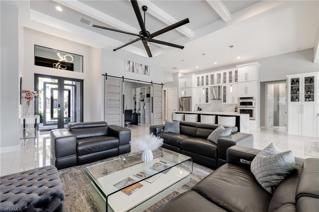 Living area featuring a barn door, recessed lighting, a ceiling fan, and french doors