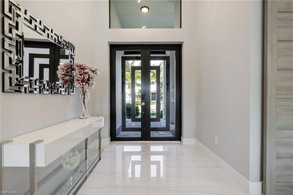 Entryway with baseboards and light marble finish flooring