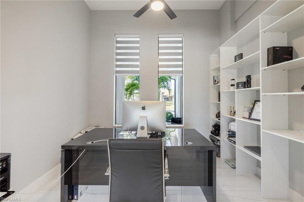 Office area with ceiling fan and baseboards
