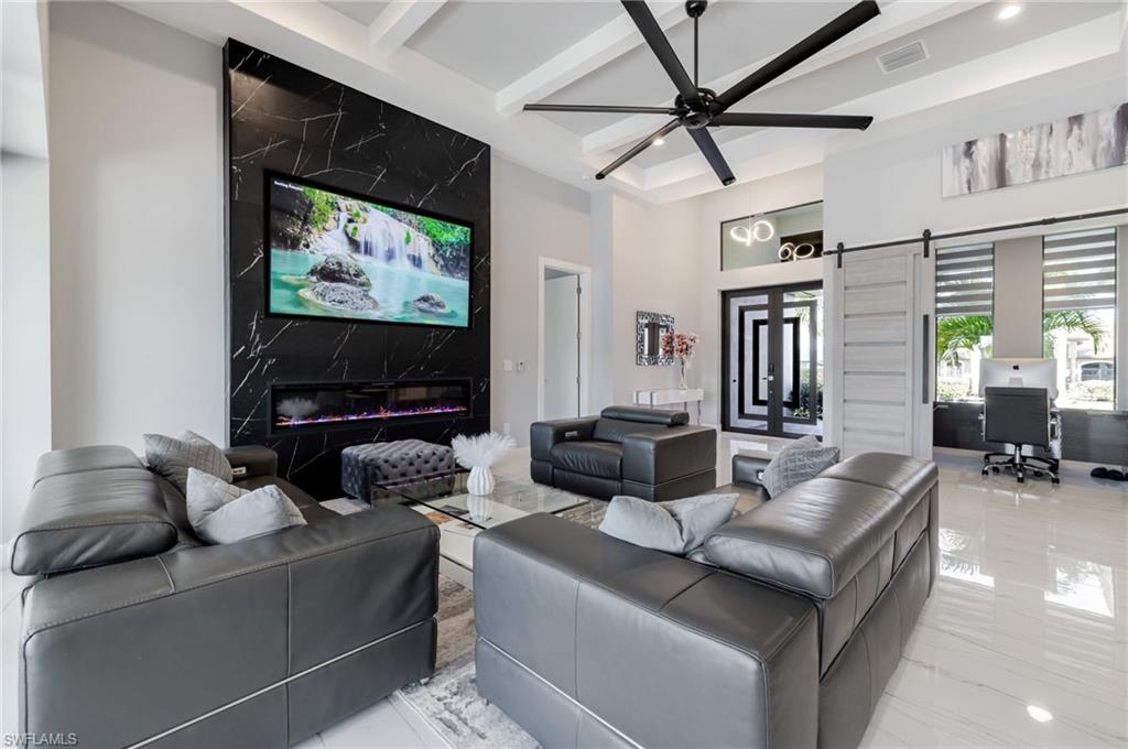Living area featuring a desk, a ceiling fan, a barn door, and recessed lighting