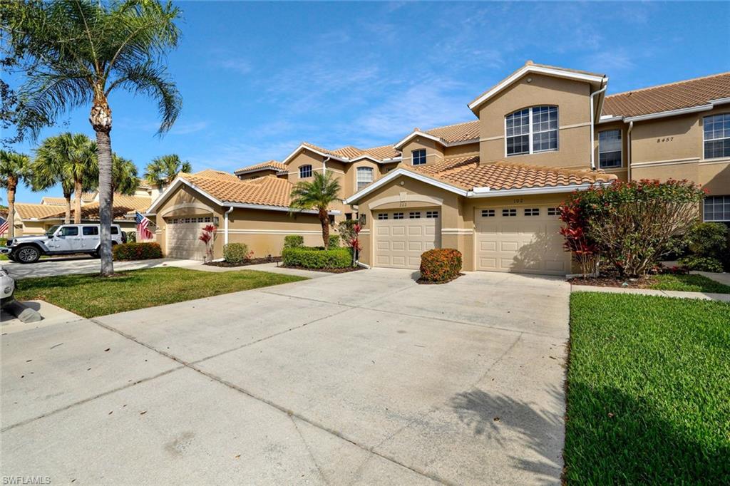 Mediterranean / spanish home featuring stucco siding, concrete driveway, a front lawn, and a tiled roof