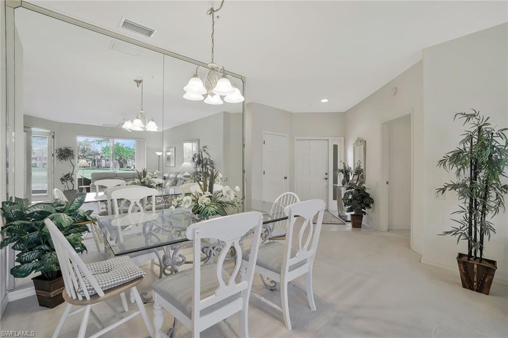 Dining room featuring hanging lights and light carpet