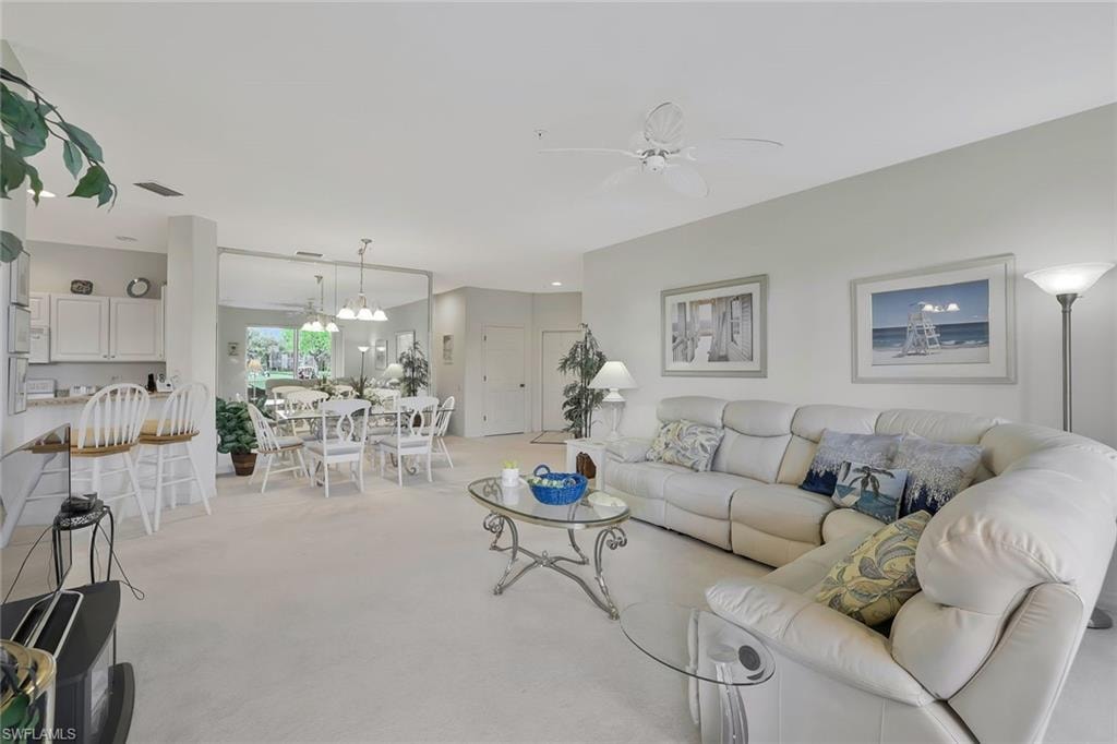 Living area with ceiling fan and light carpet
